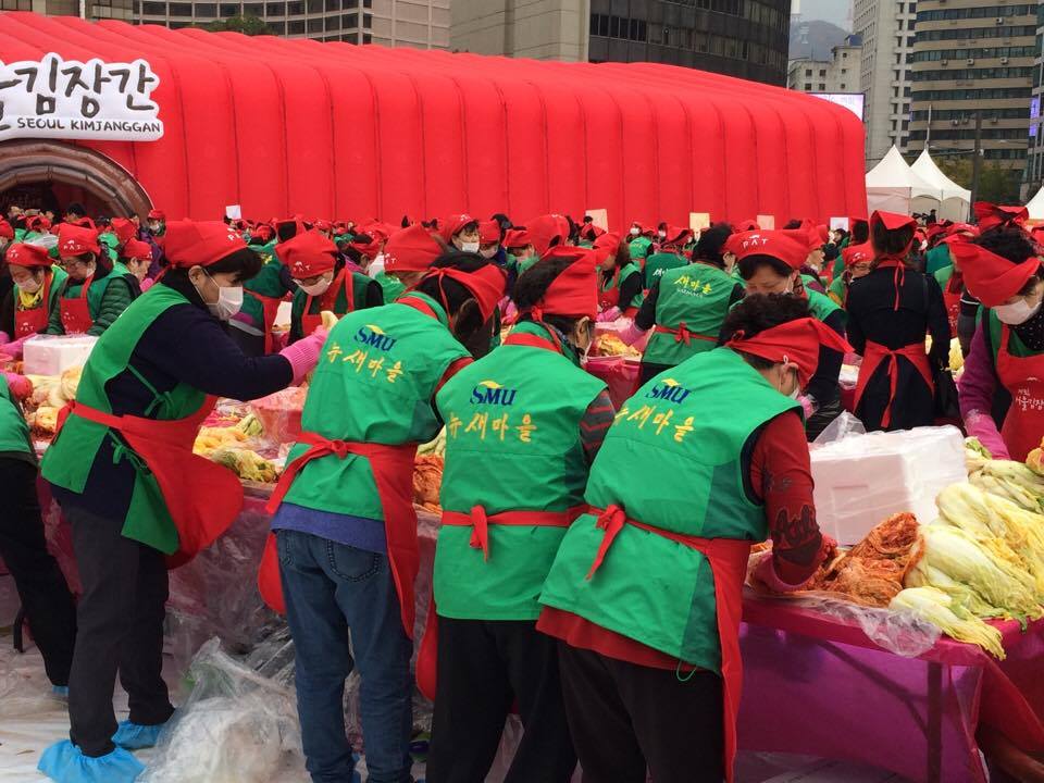 Koreanische Frauen und Männer bereiten Kimchi unter freien Himmel zu